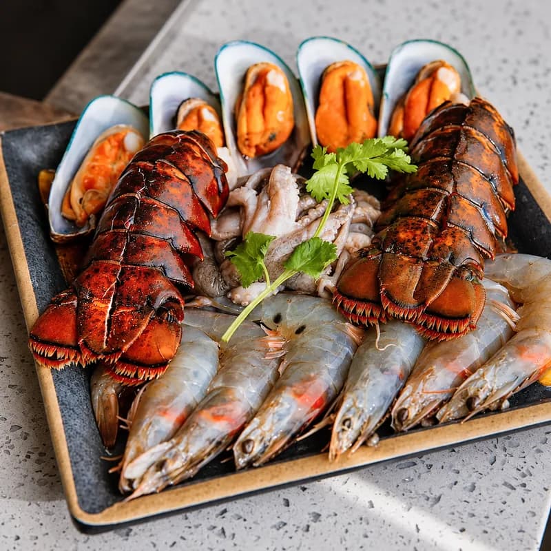 Hot pot seafood combo platter with lobster tails, green mussels and head-on shrimp