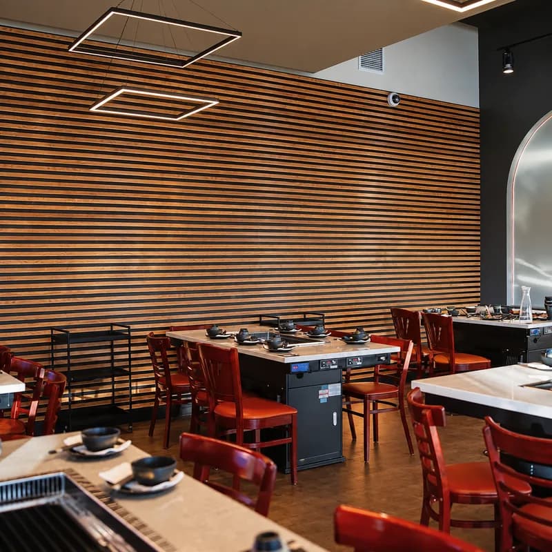 Rows of grill tables along a wood-slat wall inside Sōke