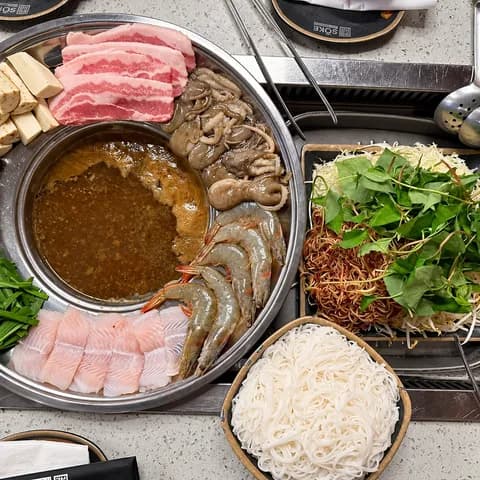 Lẩu mắm family hot pot with pork belly, shrimp, eggplant, herbs and vermicelli