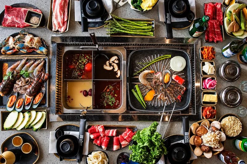 An all-you-can-eat table at Sōke: hot pot and grill in the middle, with meats, seafood, vegetables and side dishes